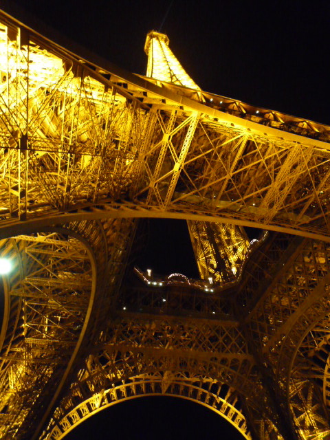 The Eiffel tower illuminated and seen from below